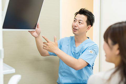 画面で根管治療後 歯根端切除術の説明をする東京の目白マリア歯科の院長